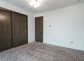 Thumbnail 24 of 57 - A room with a carpeted floor and two wooden doors. at Bristol Ridge, Urbandale, Iowa