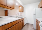 Thumbnail 33 of 57 - A kitchen with wooden cabinets and a white fridge. at Bristol Ridge, Urbandale, 50322
