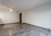 Thumbnail 11 of 57 - A room with a wooden floor and a brown door. at Bristol Ridge, Iowa, 50322