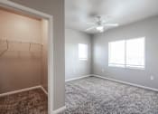 Thumbnail 7 of 35 - A room with a ceiling fan and a closet with hangers.