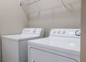 Thumbnail 13 of 35 - A white washing machine and dryer in a laundry room.