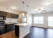 Thumbnail 31 of 35 - A kitchen with black cabinets and a white island.