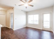 Thumbnail 32 of 35 - A room with a ceiling fan and wooden floors.