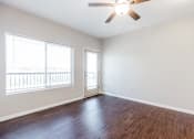 Thumbnail 8 of 35 - A room with a ceiling fan and wooden flooring.