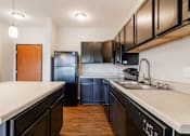 Thumbnail 4 of 35 - A kitchen with black cabinets and a black fridge.