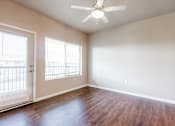 Thumbnail 2 of 35 - A room with a ceiling fan and wooden flooring.