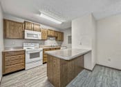 Thumbnail 30 of 33 - a kitchen with white appliances and wooden cabinets at Creekstone Falls, South Dakota, 57106