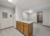 Thumbnail 18 of 33 - an empty kitchen with a counter top and a refrigerator at Creekstone Falls, Sioux Falls, SD, 57106