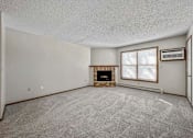 Thumbnail 29 of 33 - an empty living room with a fireplace and a window at Creekstone Falls, Sioux Falls