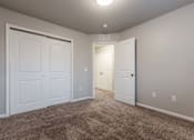 Thumbnail 3 of 30 - A room with two white doors and carpeted floor. at Danamere Village, Iowa, 50047