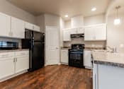 Thumbnail 8 of 30 - A kitchen with black appliances and white cabinets. at Danamere Village, Carlisle, Iowa