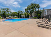 Thumbnail 37 of 66 - A swimming pool surrounded by lounge chairs and trees.
