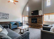 Thumbnail 39 of 66 - A living room with a fireplace and a television.