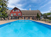 Thumbnail 32 of 66 - A large blue swimming pool in front of a red barn.