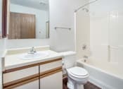 Thumbnail 13 of 24 - A white toilet sits next to a sink in a bathroom at Hunters Run Apartments, Iowa, 50208