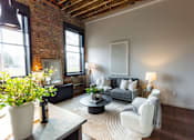 Thumbnail 20 of 99 - A living room with a grey couch and a white chair.at Plant 1 Lofts, N. Newton, 50208  