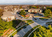 Thumbnail 76 of 90 - A parking lot is surrounded by trees and buildings at Rosemont Place Apartments, Des Moines