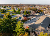 Thumbnail 61 of 90 - A parking lot is in the foreground of a residential area at Rosemont Place Apartments, Des Moines, IA