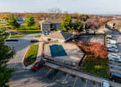 Thumbnail 66 of 90 - A parking lot with a red car and a building in the background at Rosemont Place Apartments, Iowa, 50320