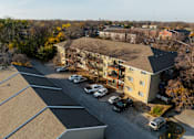 Thumbnail 62 of 90 - A parking lot with cars and a building in the background. at Rosemont Place Apartments, Des Moines, IA, 50320