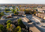 Thumbnail 57 of 90 - A large parking lot is surrounded by buildings and trees at Rosemont Place Apartments, Des Moines