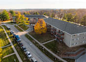 Thumbnail 55 of 90 - A parking lot with cars and a building in the background at Rosemont Place Apartments, Des Moines, Iowa
