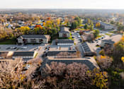 Thumbnail 81 of 90 - A parking lot is surrounded by trees and buildings. at Rosemont Place Apartments, Des Moines