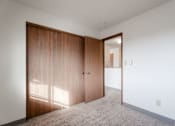 Thumbnail 35 of 90 - A room with a white wall and a brown door at Rosemont Place Apartments, Des Moines, IA