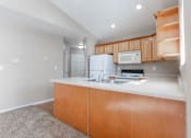 Thumbnail 21 of 42 - A kitchen with a white counter top and wooden cabinets. at Saylorville Lakeside, Polk City, IA