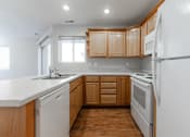 Thumbnail 19 of 42 - A kitchen with wooden cabinets and white appliances. at Saylorville Lakeside, Polk City, Iowa