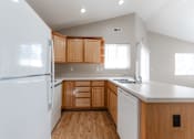 Thumbnail 24 of 42 - A kitchen with wooden cabinets and a white refrigerator. at Saylorville Lakeside, Polk City, IA, 50226