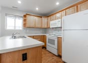 Thumbnail 23 of 42 - A kitchen with wooden cabinets and white appliances. at Saylorville Lakeside, Polk City, 50226
