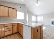Thumbnail 20 of 42 - A kitchen with wooden cabinets and a white dishwasher. at Saylorville Lakeside, Polk City