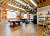 Thumbnail 14 of 25 - A room with a wooden floor and a brick wall at Spaulding Lofts Apartments, Iowa, 50112
