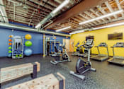 Thumbnail 20 of 25 - A gym with a variety of exercise equipment including treadmills, stationary bikes, and weight machines at Spaulding Lofts Apartments, Iowa, 50112