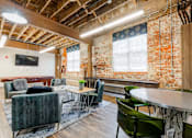Thumbnail 9 of 25 - A room with a couch, chairs, and a table at Spaulding Lofts Apartments, IA, 50112