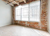 Thumbnail 5 of 28 - A room with a large window and a brick wall.