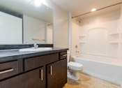 Thumbnail 7 of 28 - A bathroom with a white toilet and a white bathtub.