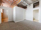 Thumbnail 4 of 28 - A room with white walls and a brick wall in the background.