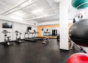 Thumbnail 39 of 50 - A gym with a variety of equipment including a rowing machine.