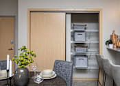 Thumbnail 12 of 31 - a dining room with a table and chairs and an open refrigerator at Lake Shore Apartments, Ankeny, 50021