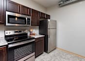 Thumbnail 15 of 31 - a kitchen with stainless steel appliances and a refrigerator at Lake Shore Apartments, Ankeny
