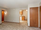 Thumbnail 1 of 13 - an empty living room and kitchen with a door open to a bedroom at Lake Shore Place Apartments, Ankeny, Iowa