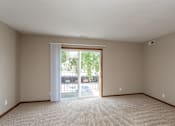 Thumbnail 2 of 13 - an empty living room with sliding glass doors to a patio at Lake Shore Place Apartments, Ankeny