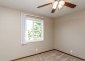 Thumbnail 6 of 13 - an empty bedroom with a ceiling fan and a window at Lake Shore Place Apartments, Ankeny, IA