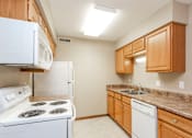 Thumbnail 4 of 13 - a kitchen with white appliances and granite counter tops at Lake Shore Place Apartments, Iowa, 50021