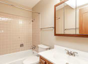Thumbnail 7 of 13 - a bathroom with a tub sink and toilet and a mirror at Lake Shore Place Apartments, IA, 50021