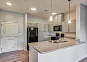 Thumbnail 9 of 22 - A kitchen with a granite countertop and a sink.