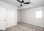 Thumbnail 54 of 56 - A room with a ceiling fan and a window with blinds at Meadowlark Place Apartments, IA, 50111