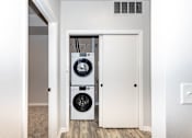 Thumbnail 52 of 56 - A white door is open to reveal a black washing machine and dryer at Meadowlark Place Apartments, Grimes, IA